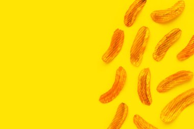 Baharatlı atıştırmalık, muz dilimli kırmızı biber aromalı sarı arka planda..