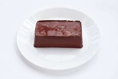 Beyaz arka planda beyaz tabakta domuz kanı pudingi..