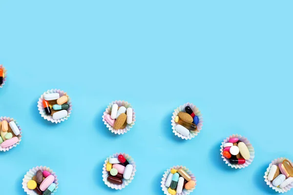 Színes Tabletták Kapszulákkal Tablettákkal Kék Hátterű Muffin Csomagolásban — Stock Fotó