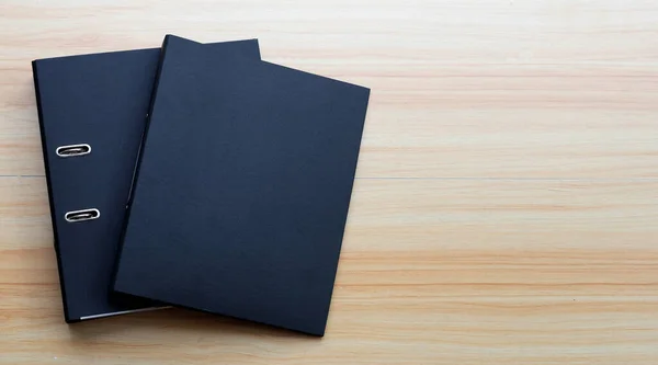 木制纹理背景的黑色办公室文件夹 — 图库照片