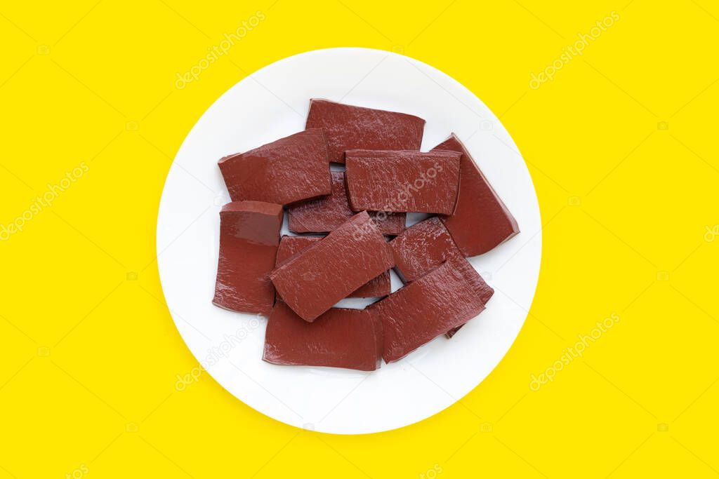 Pork blood pudding in white plate on yellow background.
