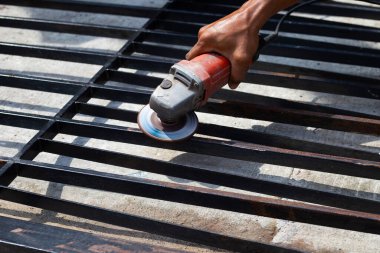 Yaklaş, üçkağıtçıyla çalışan bir adam. Demir kapı onarımı