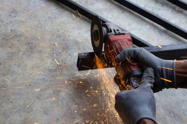 Yaklaş, üçkağıtçıyla çalışan bir adam. Demir kapı onarımı