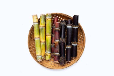 Beyaz arka planda bambu sepetinde şeker kamışı.