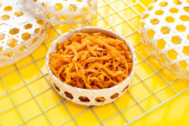 Sarı arka planda bambu sepeti içinde turşu turşusu..