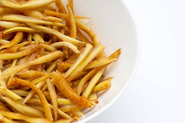 Dilimlenmiş parmak kökü beyaz arka planda beyaz kâsede.