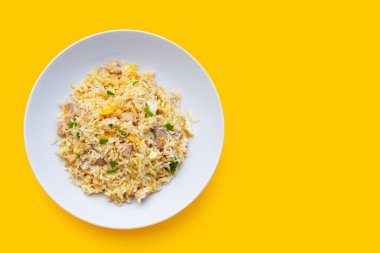 Sarı arka planda beyaz tabakta kızarmış pirinç.. 