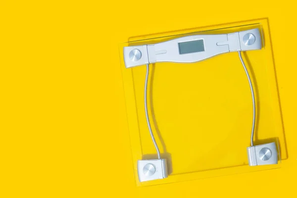 黄色の背景にデジタル体重計 — ストック写真
