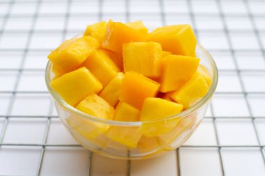 Tropik meyve, mango küp beyaz arka planda cam kasede dilimler..