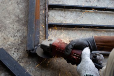 Yaklaş, üçkağıtçıyla çalışan bir adam. Demir kapı onarımı