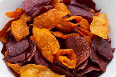 Beyaz kasede mor ve sarı patates cipsi