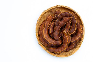 Bambu sepetinde beyaz arka planda demirhindi tropikal meyvesi. Üst görünüm