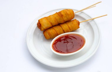 Kızarmış hamur aperatifleri beyaz arka plana sarılmış sosisler..