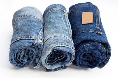 Beyaz arka planda yuvarlanmış mavi kot pantolon