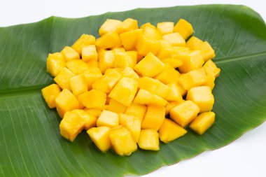 Tropik meyve, muz yaprağında mango küp dilimleri.