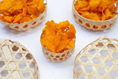 Beyaz arka planda bambu sepeti içinde patates cipsi..