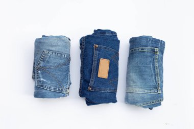 Beyaz arka planda yuvarlanmış mavi kot pantolon