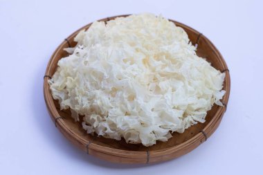 Beyaz arka planda bambu sepeti içinde Tremella Mantarı.