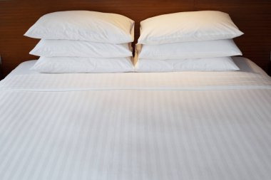 Yatak odasındaki otelde yastıklı yatak 