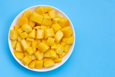 Tropikal meyve, Mango küp dilimleri mavi arka planda beyaz tabakta.