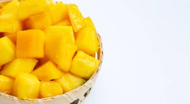 Tropikal meyve, beyaz arka planda bambu sepetinde mango küp dilimleri..