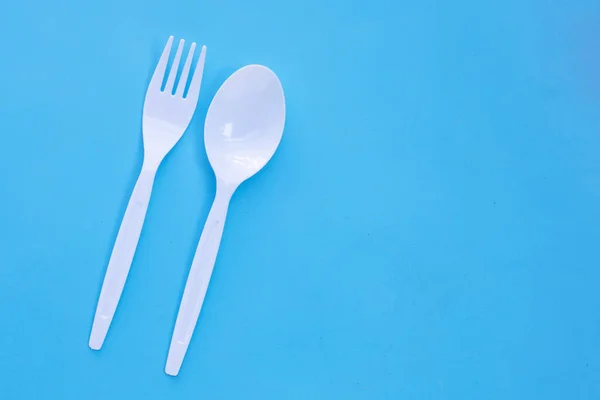 蓝色背景的塑料叉子和勺子 — 图库照片