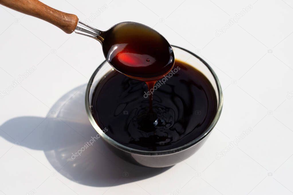 Oyster sauce in glass bowl on white background.