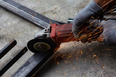 Yaklaş, üçkağıtçıyla çalışan bir adam. Demir kapı onarımı