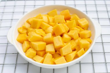 Tropik meyve, mango küp beyaz arka planda beyaz kasede dilimler..