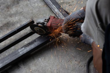 Yaklaş, üçkağıtçıyla çalışan bir adam. Demir kapı onarımı