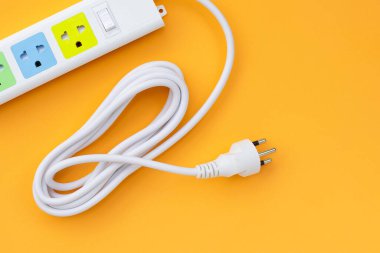 Elektrik kablosu ve fişi sarı arka planda. Üst görünüm