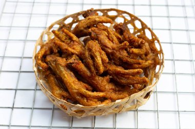 Kızarmış tavuk ayağı ve beyaz arka planda bambu sepeti..