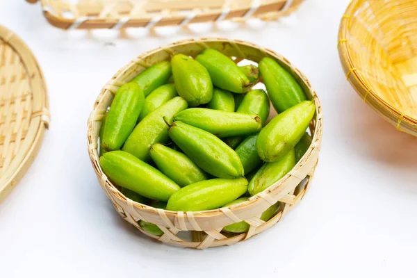 Bilimbi meyvesi beyaz arka planda bambu sepetinde.