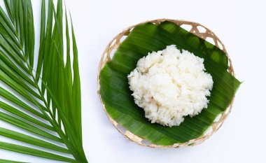 Muz yaprağına yapış yapış pirinç, beyaz arka planda bambu sepeti..