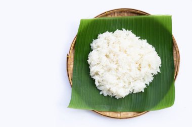 Muz yaprağına yapış yapış pirinç, beyaz arka planda bambu sepeti..