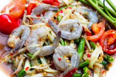 Beyaz tabakta karidesli Papaya salatası