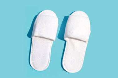 Mavi arka planda otel terlikleri. Boşluğu kopyala