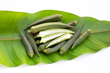 Beyaz arka planda yeşil yapraklı taze bamya