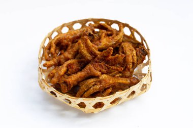 Kızarmış tavuk ayağı ve beyaz arka planda bambu sepeti..