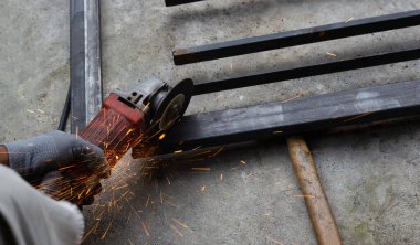 Yaklaş, üçkağıtçıyla çalışan bir adam. Demir kapı onarımı