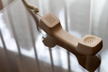 Cam masadaki sabit telefon ahizesi.