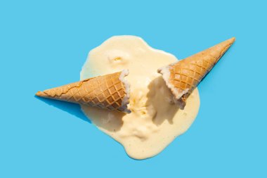 Mavi arka planda waffle külahlı dondurma topları eritiliyor.