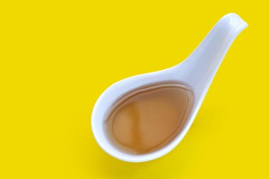 Sarı arka planda kaşık içinde balık sosu