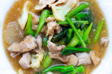 Soslu domuz eti ve lahana ile kızarmış düz erişte.