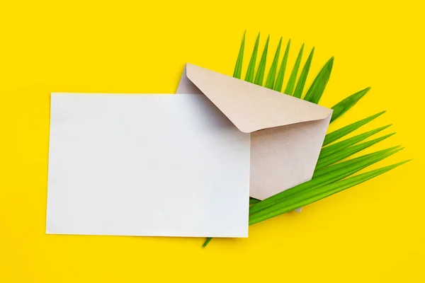 Envelope Com Papel Branco Folhas Palma Fundo Amarelo — Fotografia de Stock