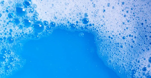 Detergent foam bubble on blue background.