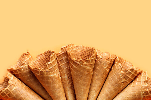 Empty ice cream cone on yellow background.