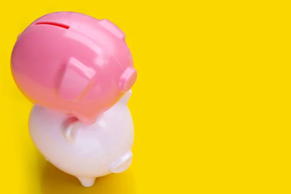 Pink piggy bank on yellow background.