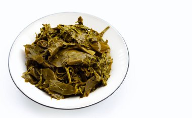 Senna siamea beyaz arka planda bambu sepetinde kaynamış yapraklar.