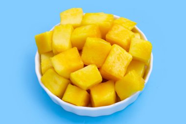 Tropik meyve, mavi arkaplanda mango küp dilimleri.
